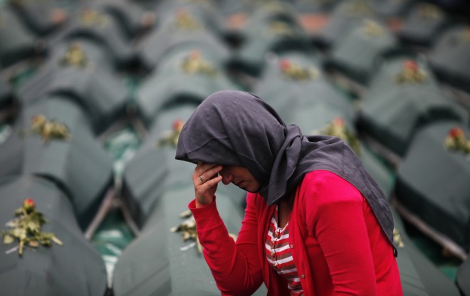 A Bosniak woman woman cries next to coffins during a mass funeral for victims from Visegrad. (2012)