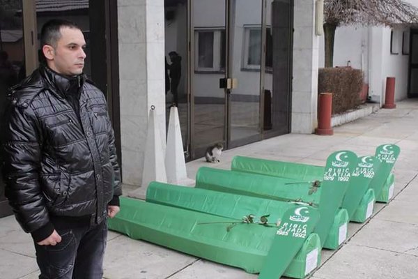 Zijad stands by the coffins of his newly identifed family members. 